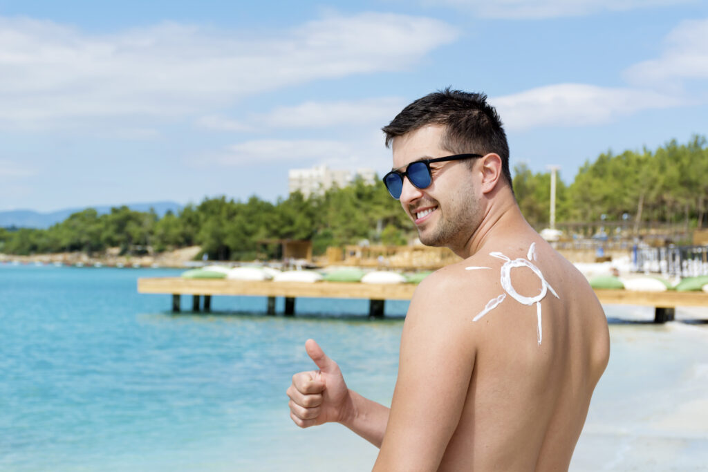 happy look of a man after applying of sunscreen on his skin.