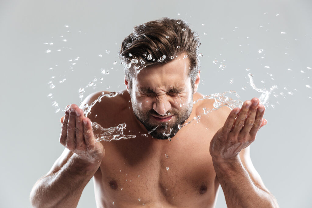 man washing his face for the purpose of giving his skin a healthy look.